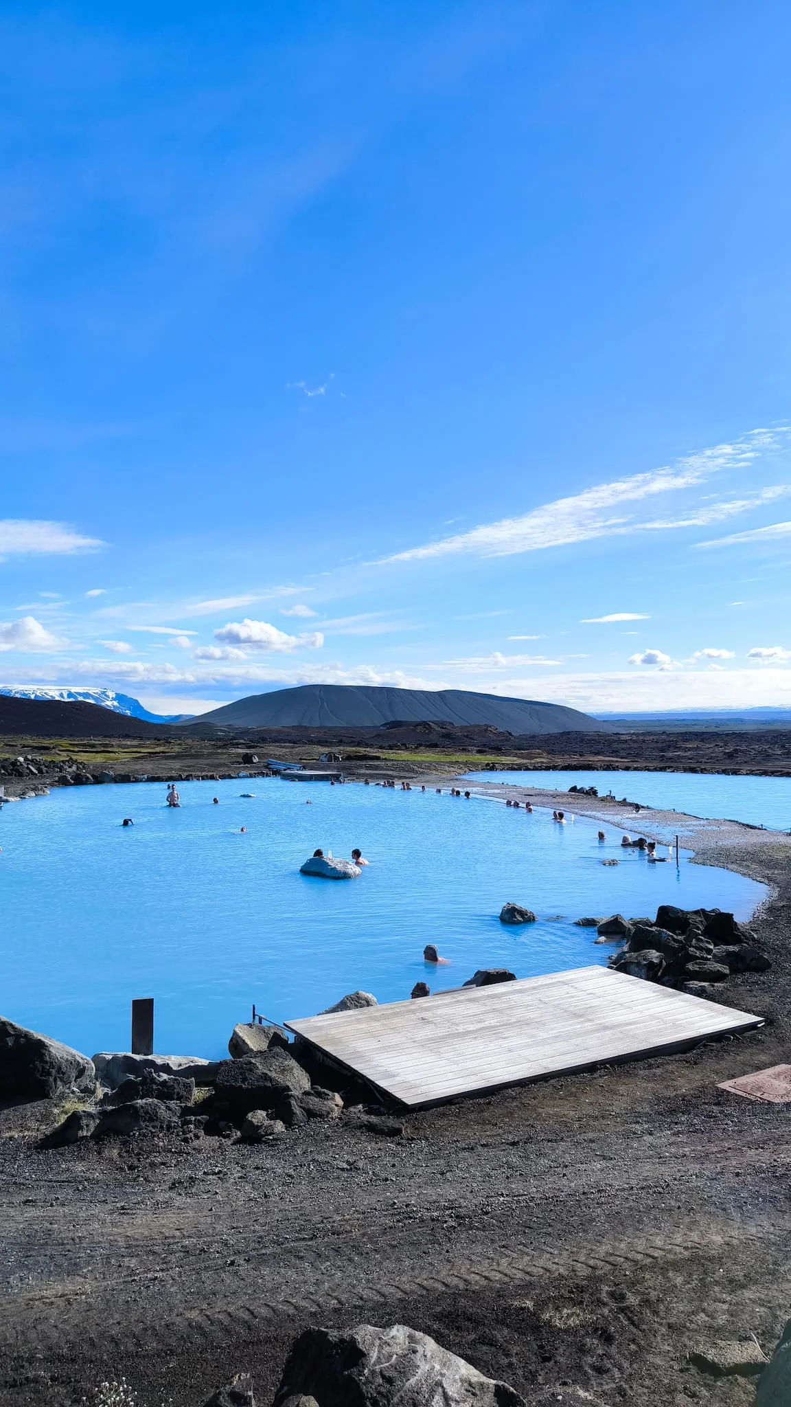 Mývatn Nature Baths — aguas termales azul turquesa con volcán al fondo y cielo despejado