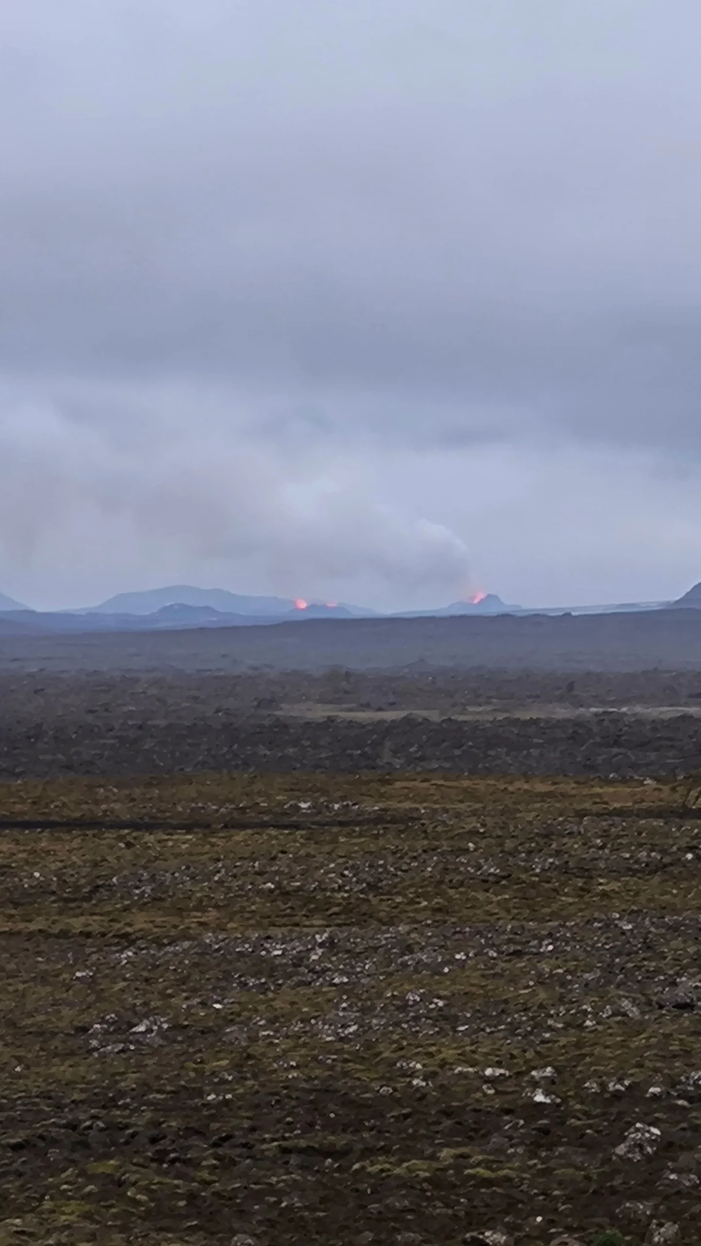Volcán en erupción en la península de Reykjanes visto desde la carretera de camino al aeropuerto
