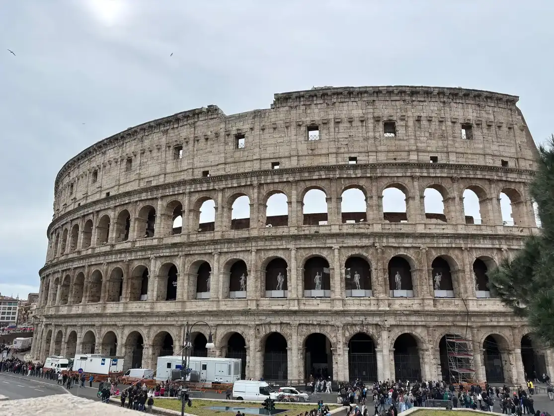 Vista exterior del Coliseo de Roma con turistas en la entrada