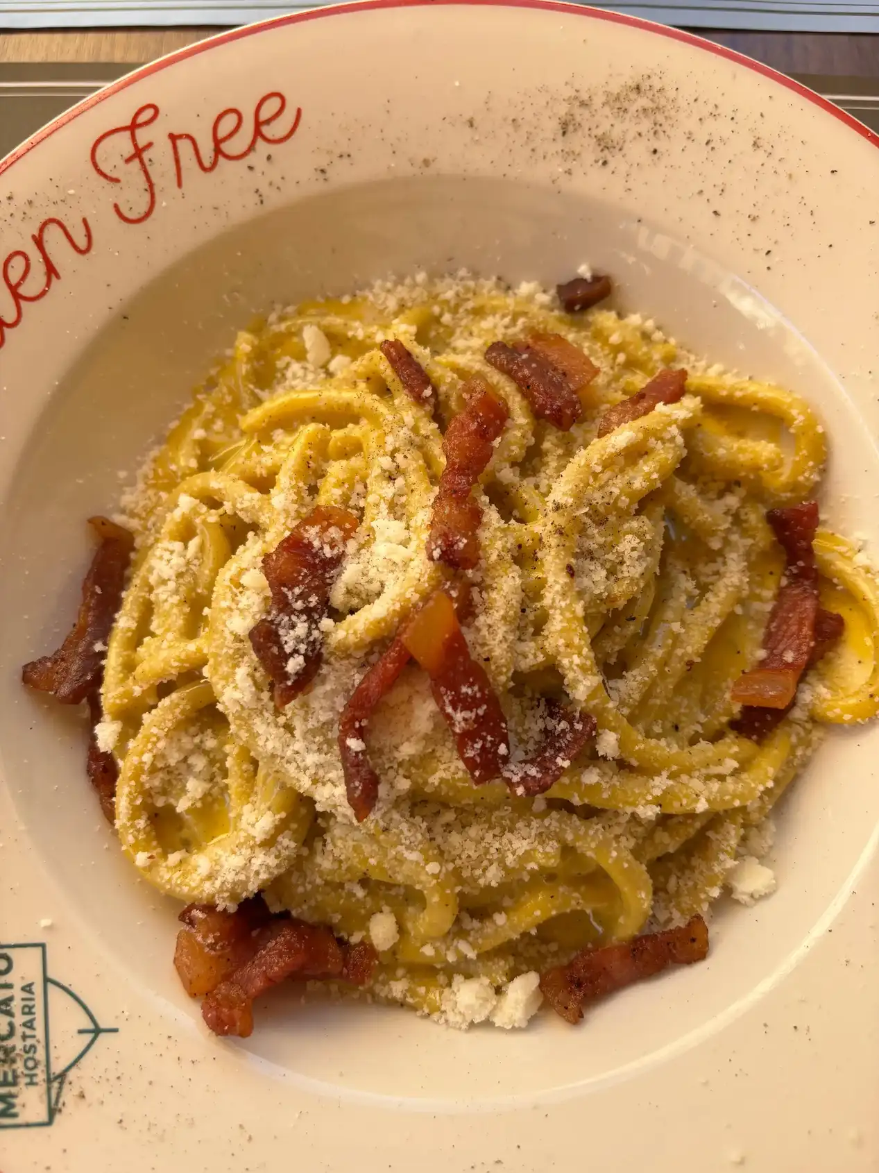 Carbonara sin gluten en plato con inscripción Gluten Free en Mercato Hostaria Roma