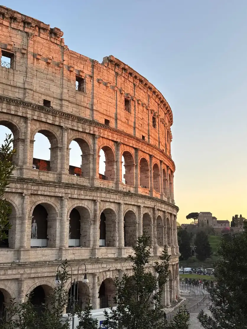 El Coliseo de Roma iluminado de noche con sus arcos en color dorado