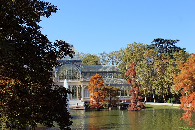 Imagen del Palacio de Cristal, junto a un lago, en el Parque del Retiro de Madrid. Sin duda uno de los sitios turísticos en Madrid gratis más lindos de todos.