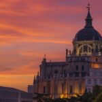 Catedral de la Almudena sobre un fondo de cielo naranja durante el atardecer